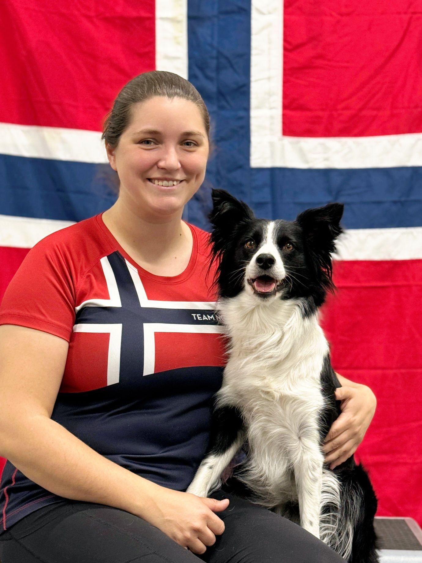 Ariane Wieber and her border collie in front of a Norwegian flag